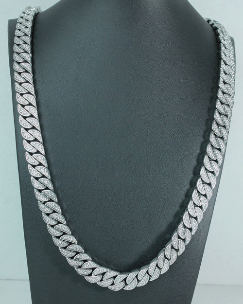 A thick silver Cuban link chain necklace displayed on a black neck mannequin against a light gray background.
