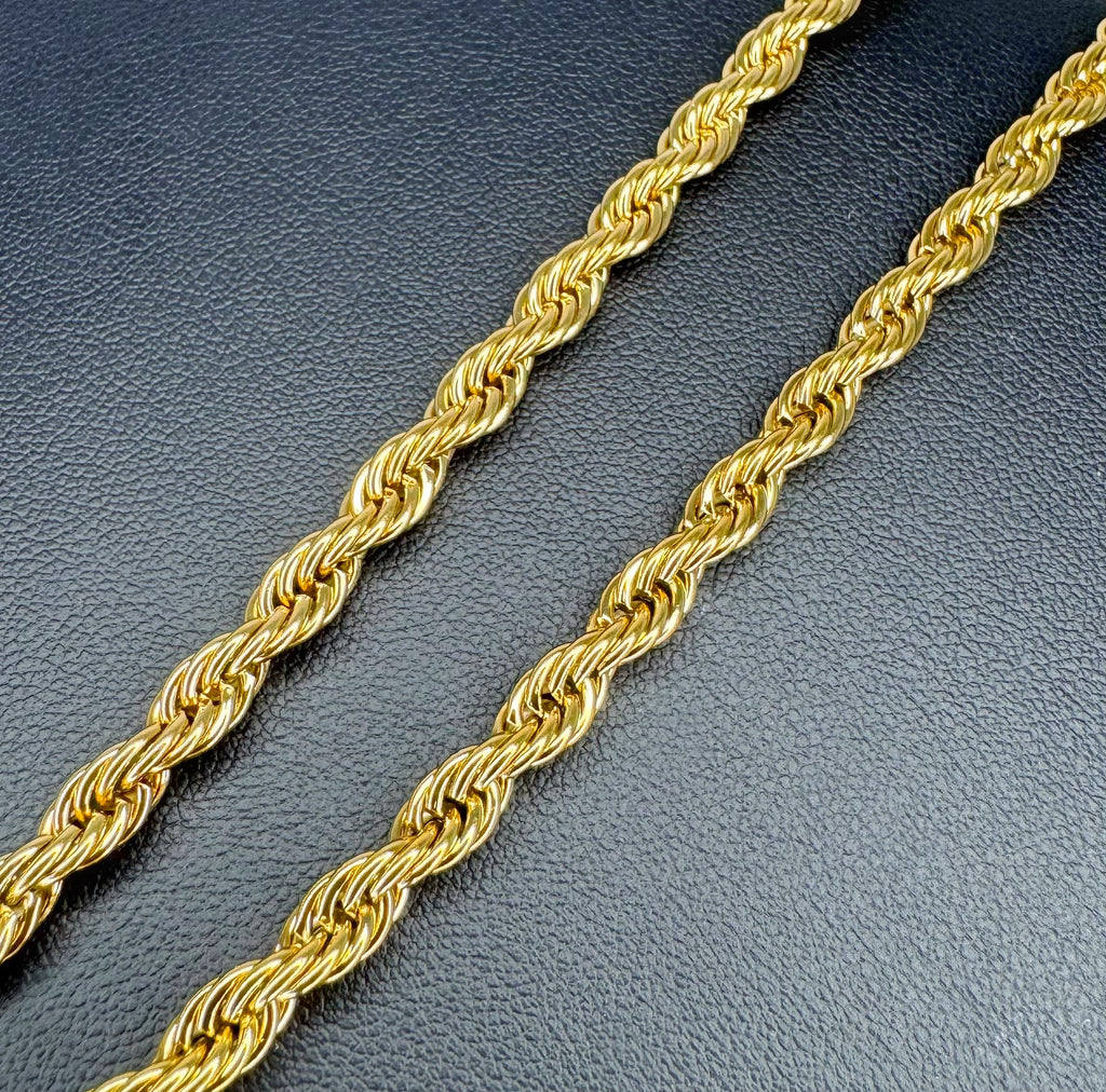 Gold rope chain on a dark textured surface