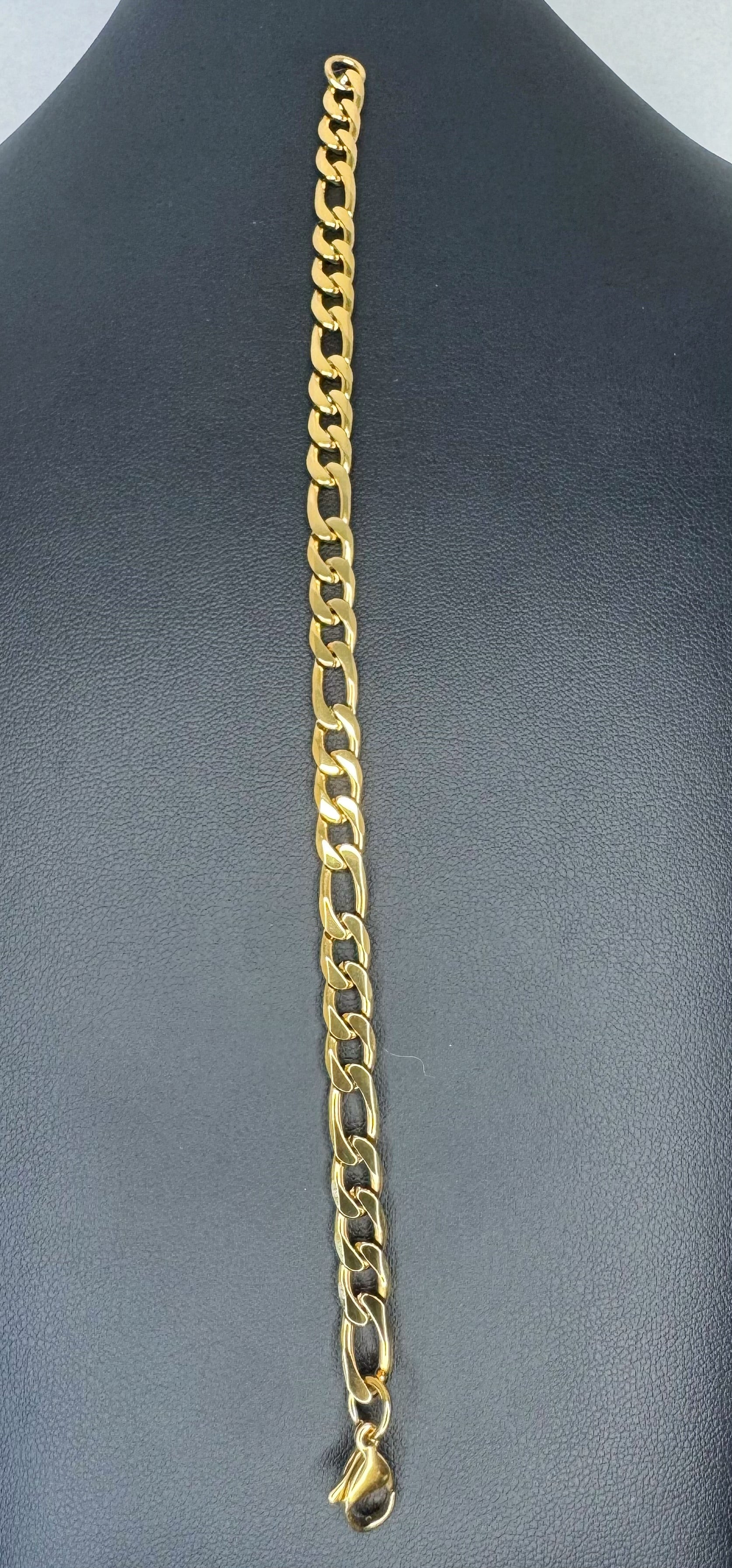 Gold chain necklace on a gray mannequin
