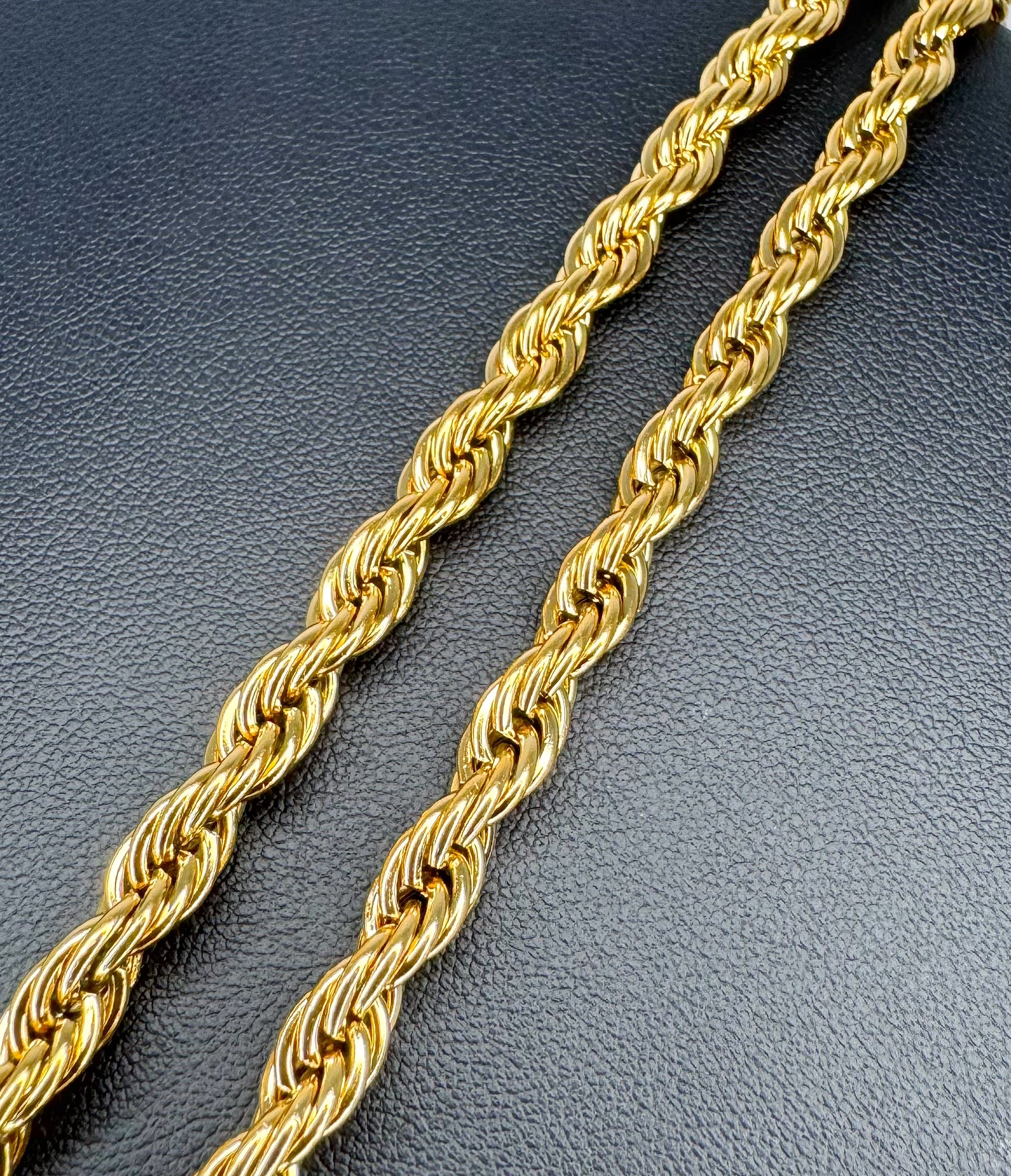 Gold rope chain on a dark textured surface