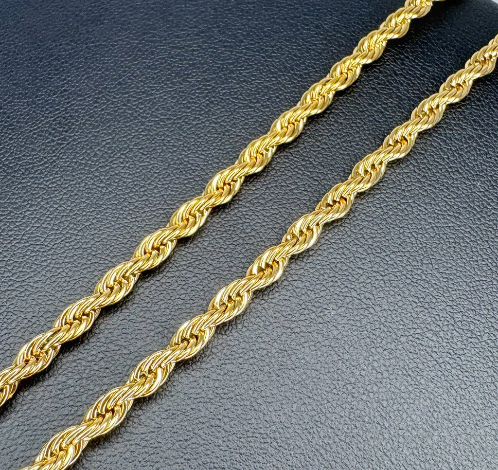 Gold rope chain on a textured dark surface