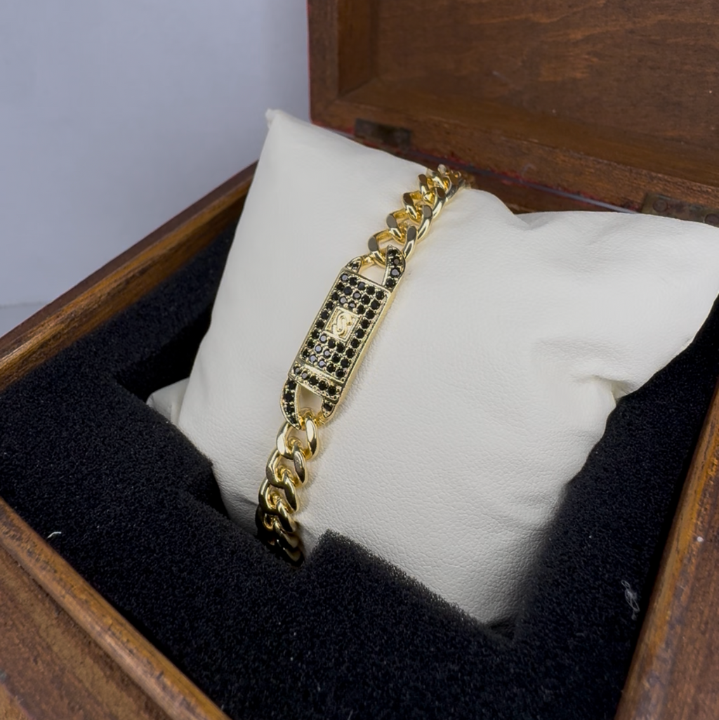 Gold bracelet in a wooden box with a white cushion