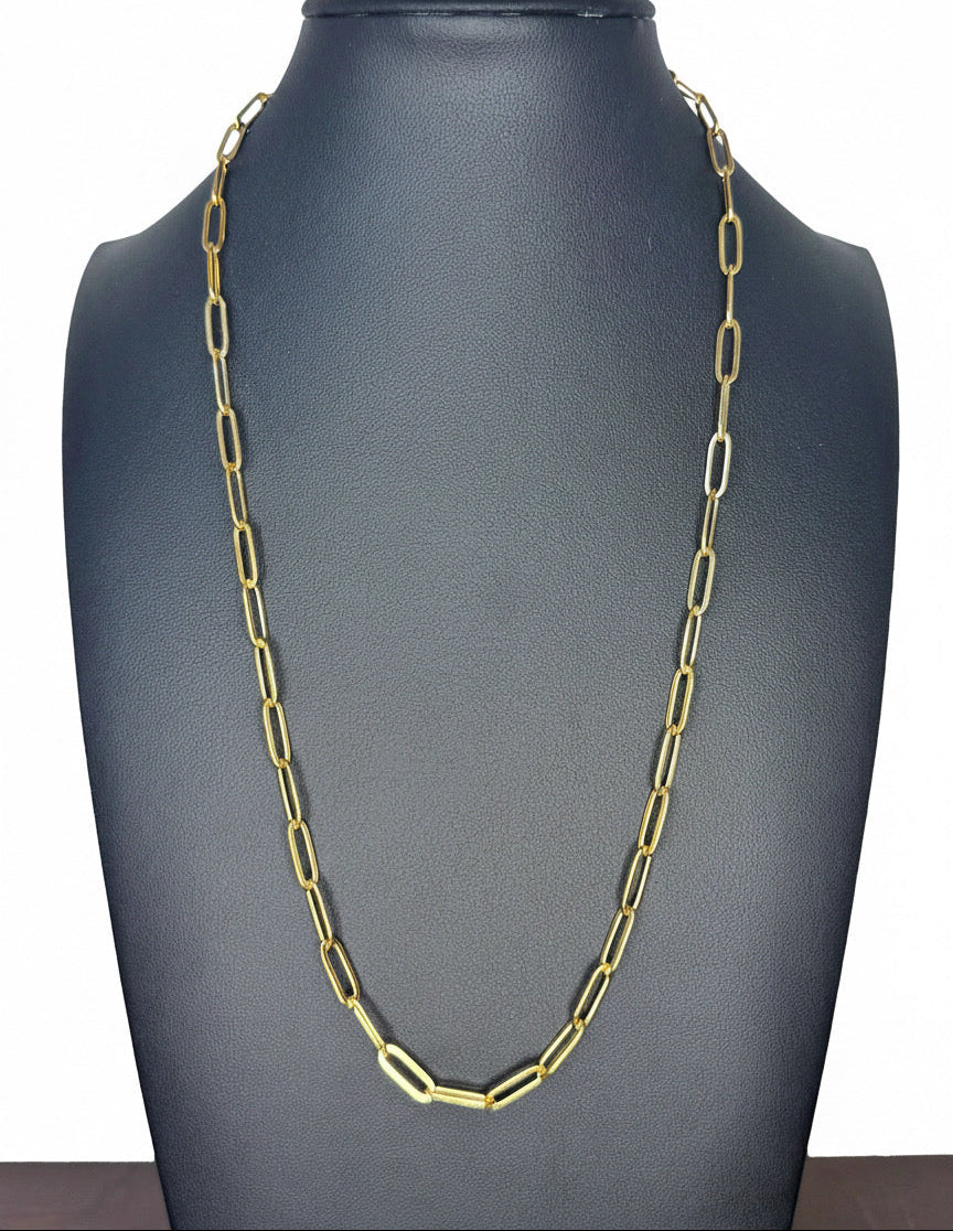 A gold paperclip chain necklace displayed on a matte black jewelry bust against a white background.