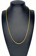 Gold chain necklace on a black mannequin bust against a white background