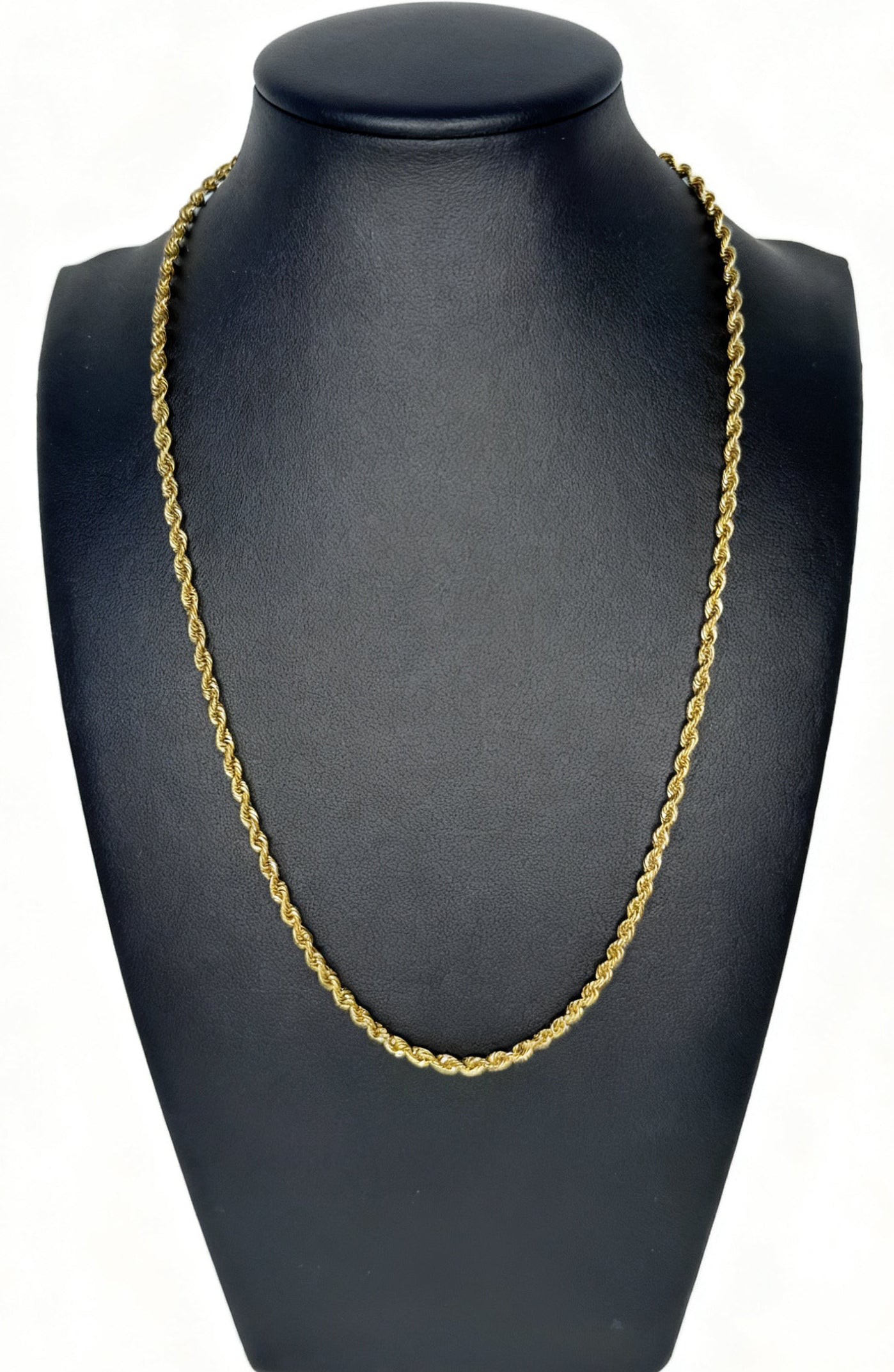 Gold chain necklace on a black mannequin bust against a white background