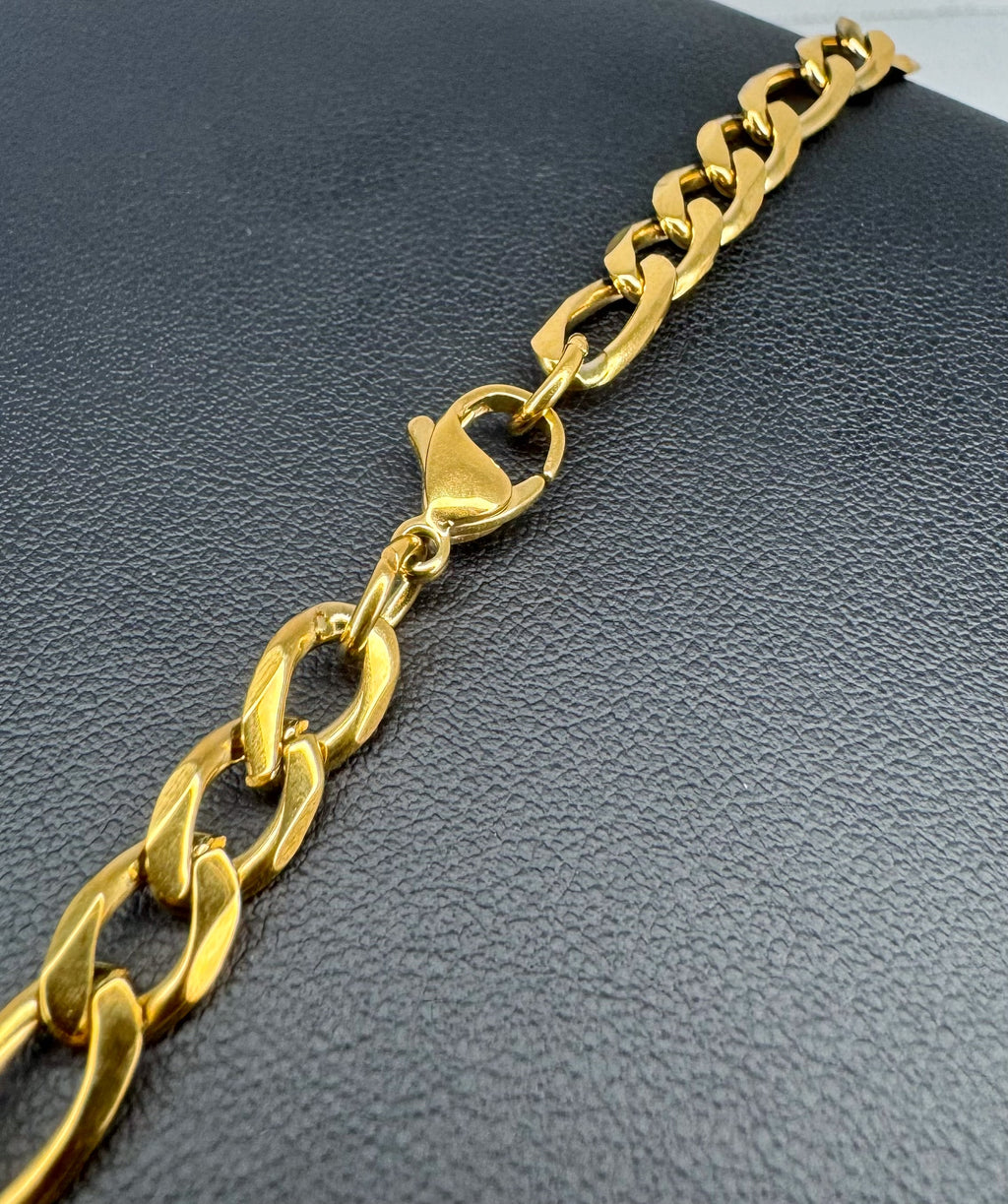 Gold chain bracelet on a dark textured surface