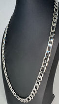 A silver-toned Figaro link chain necklace displayed on a black mannequin bust against a light gray background.