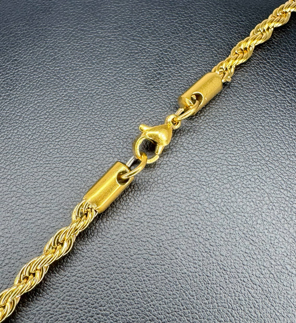 Gold rope chain on a textured gray surface
