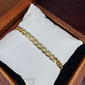 Gold chain bracelet on a white cushion inside a wooden box