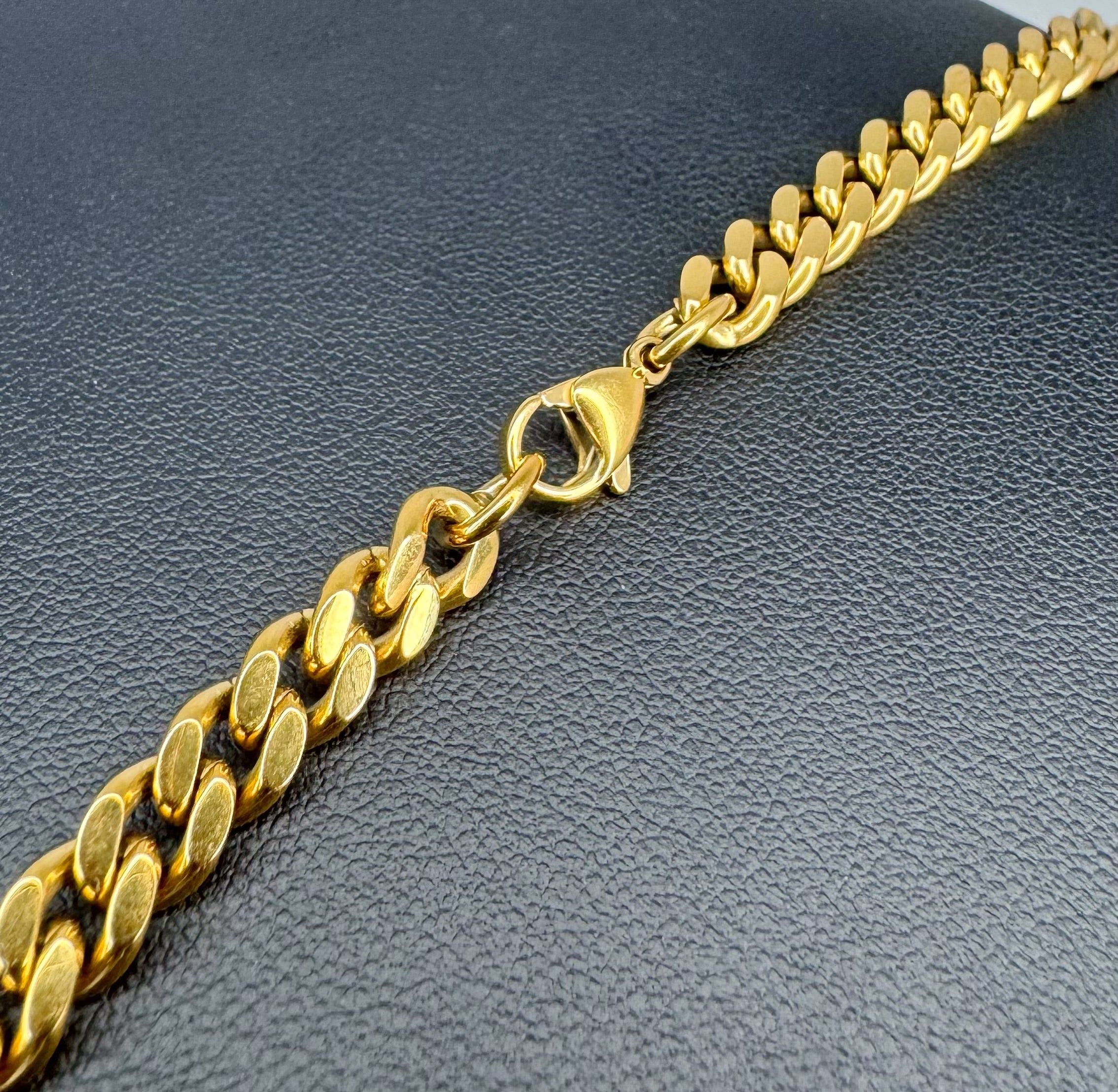 Gold chain bracelet on a dark gray textured surface