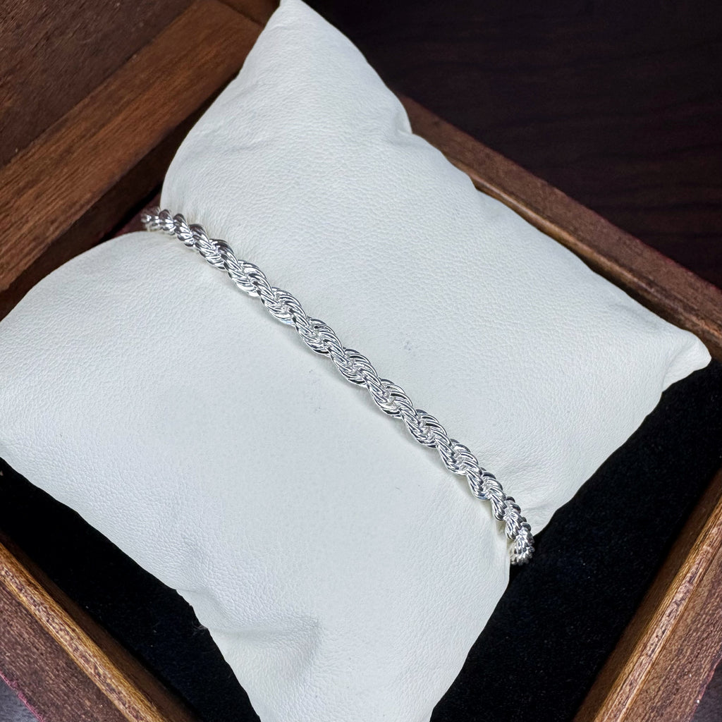 Silver bracelet on a white cushion inside a wooden box