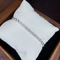 Silver bracelet on a white cushion inside a wooden box