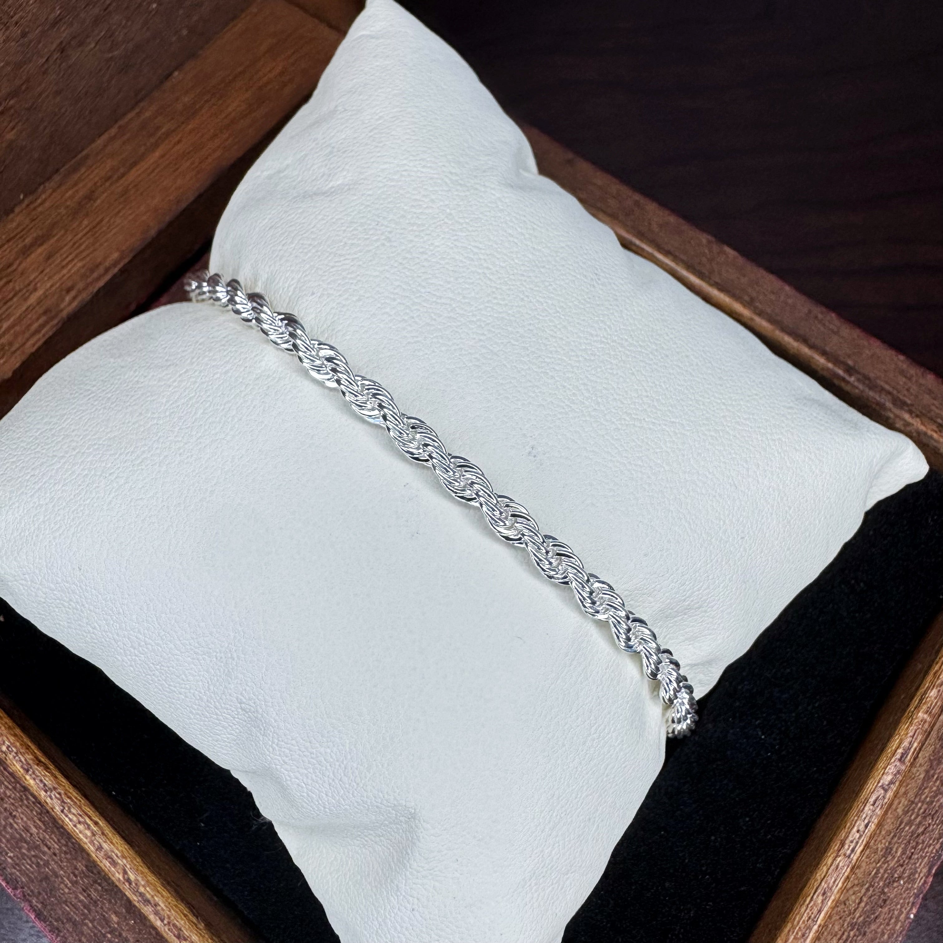 Silver bracelet on a white cushion inside a wooden box