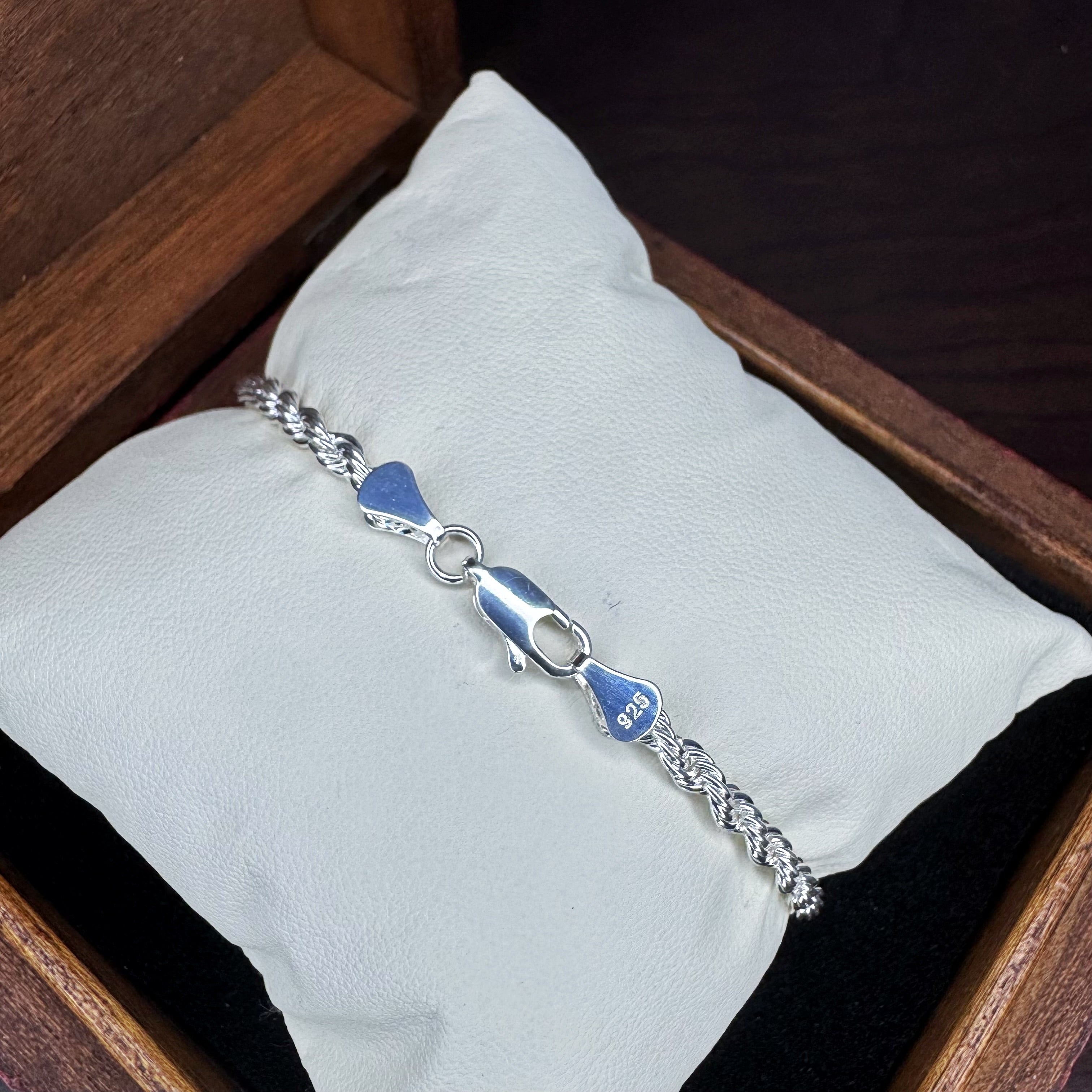Silver bracelet with blue accents on a white pillow