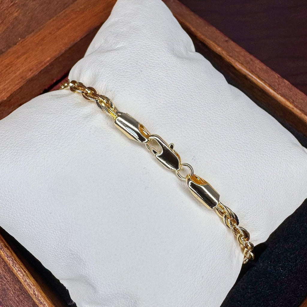 Gold bracelet on a white cushion inside a wooden box