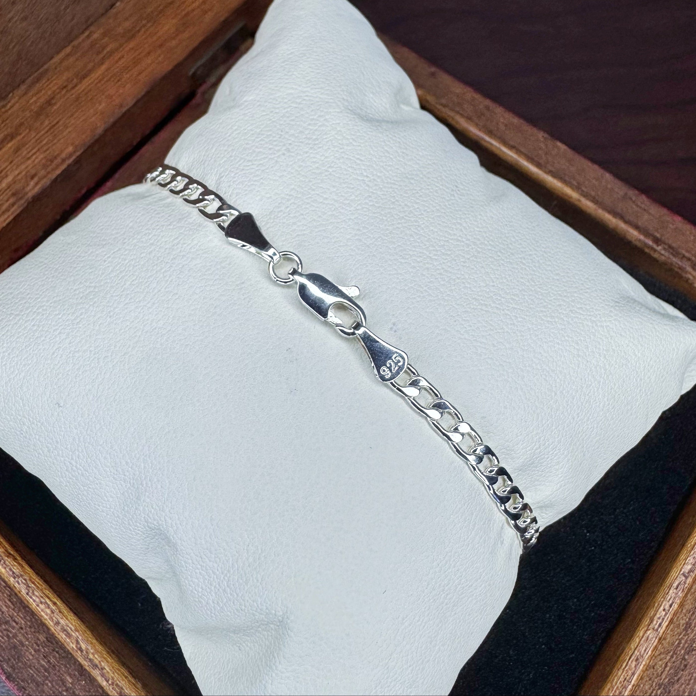Silver bracelet on a white cloth with a wooden background