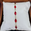Bracelet with red gemstones on a white cushion