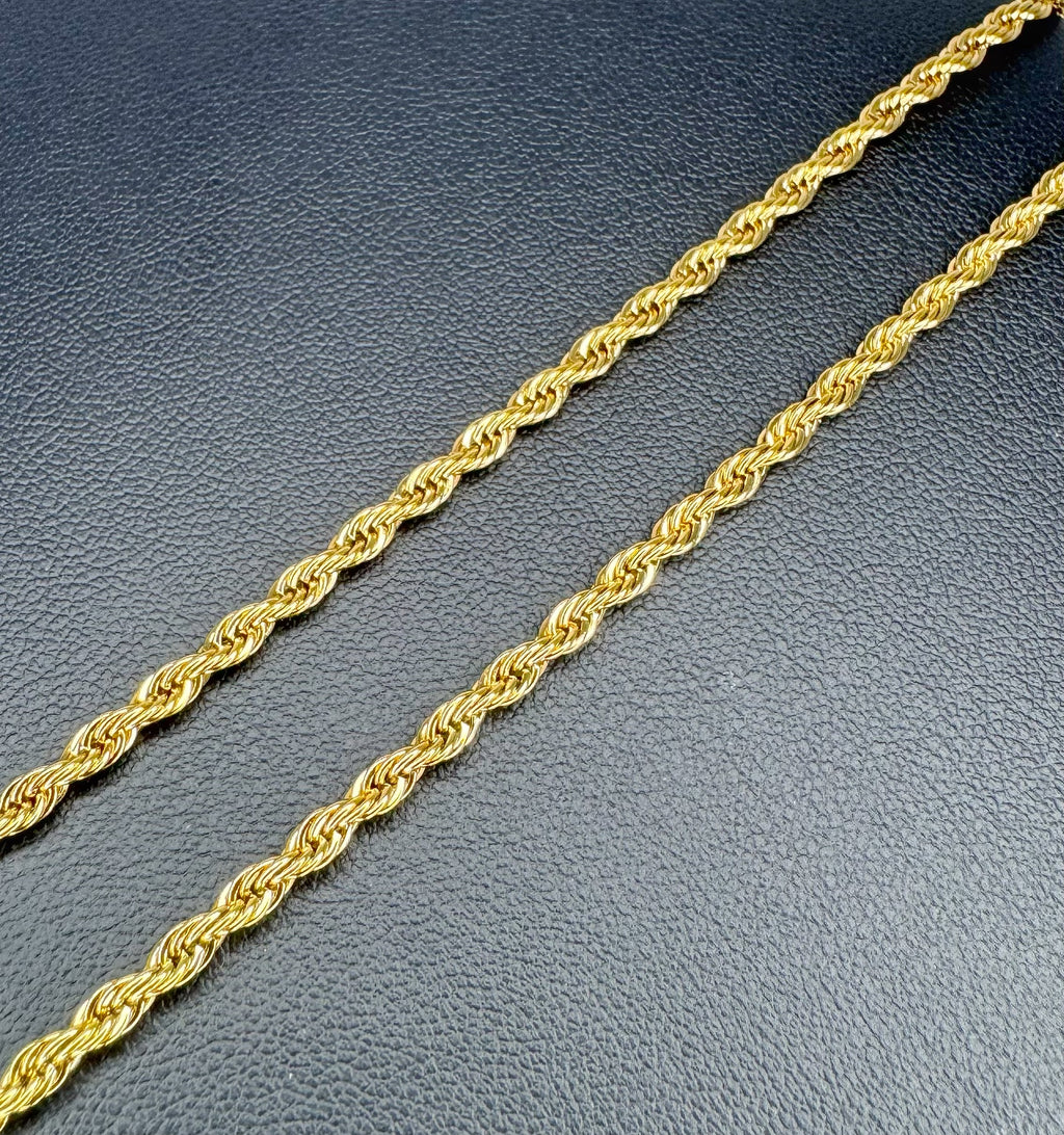 Gold rope chain on a textured gray surface
