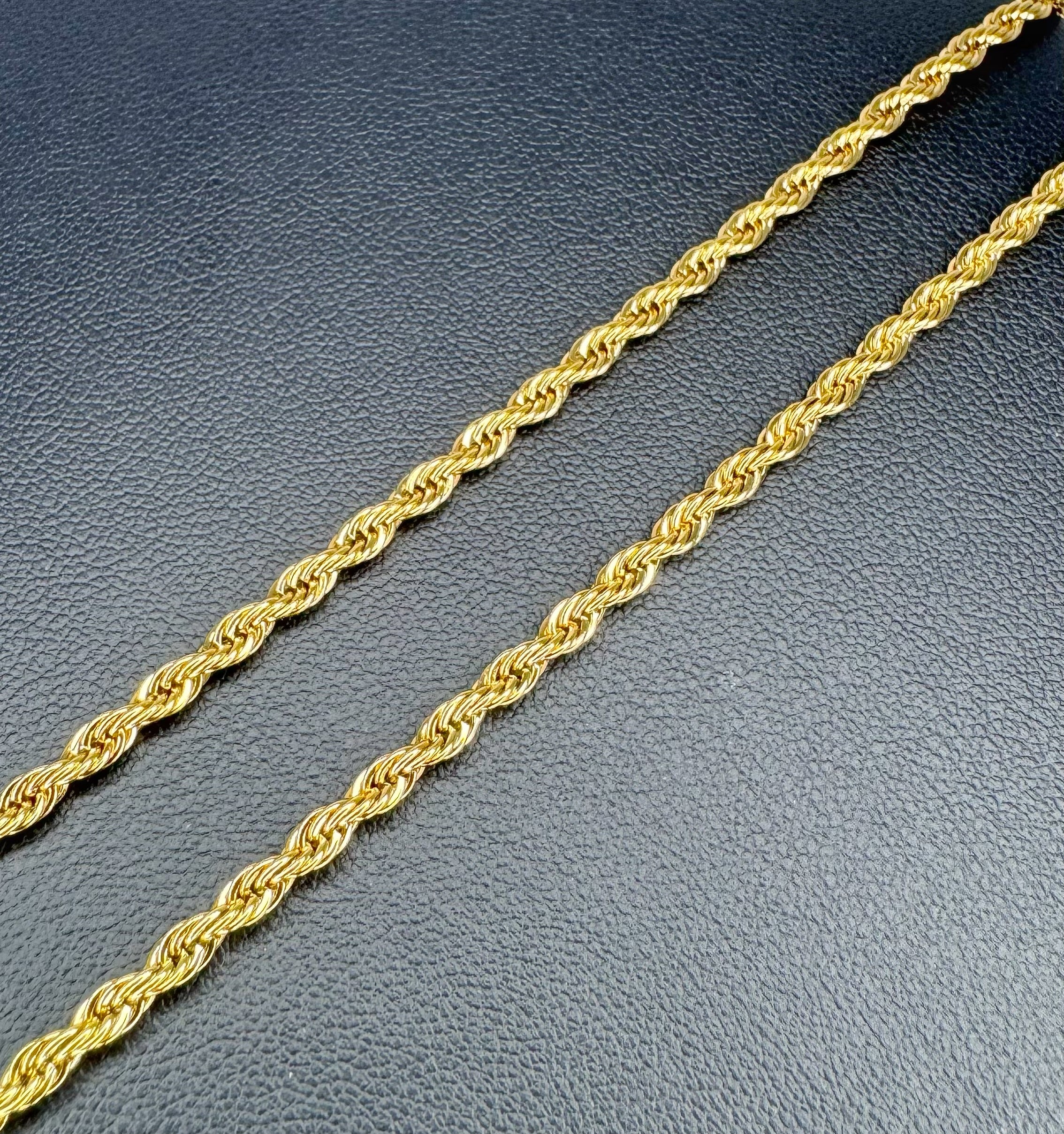 Gold rope chain on a textured gray surface