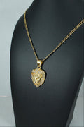 A gold chain necklace with a textured lion head pendant, displayed on a black mannequin bust against a light gray background.